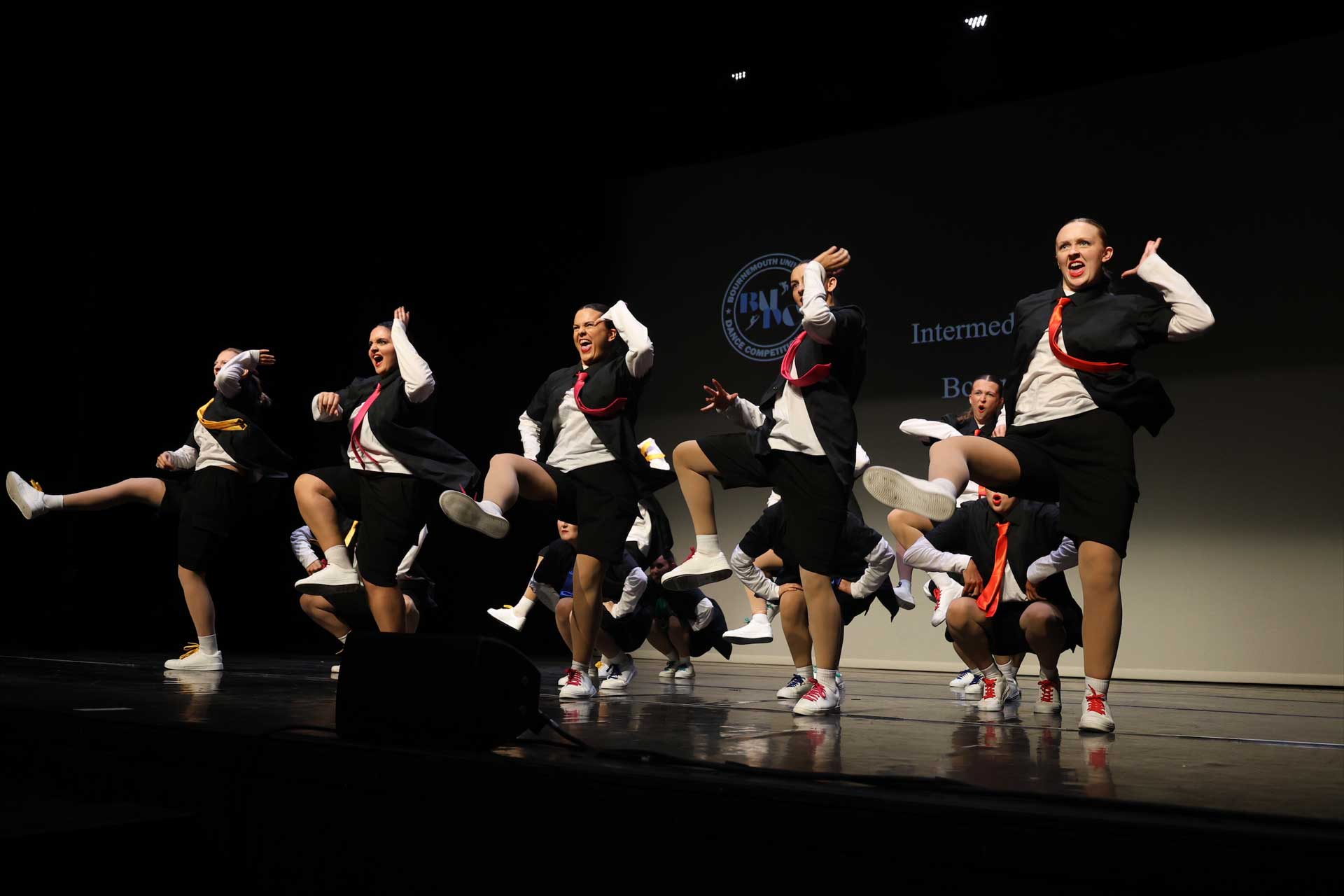 Students performing a dance routine on stage